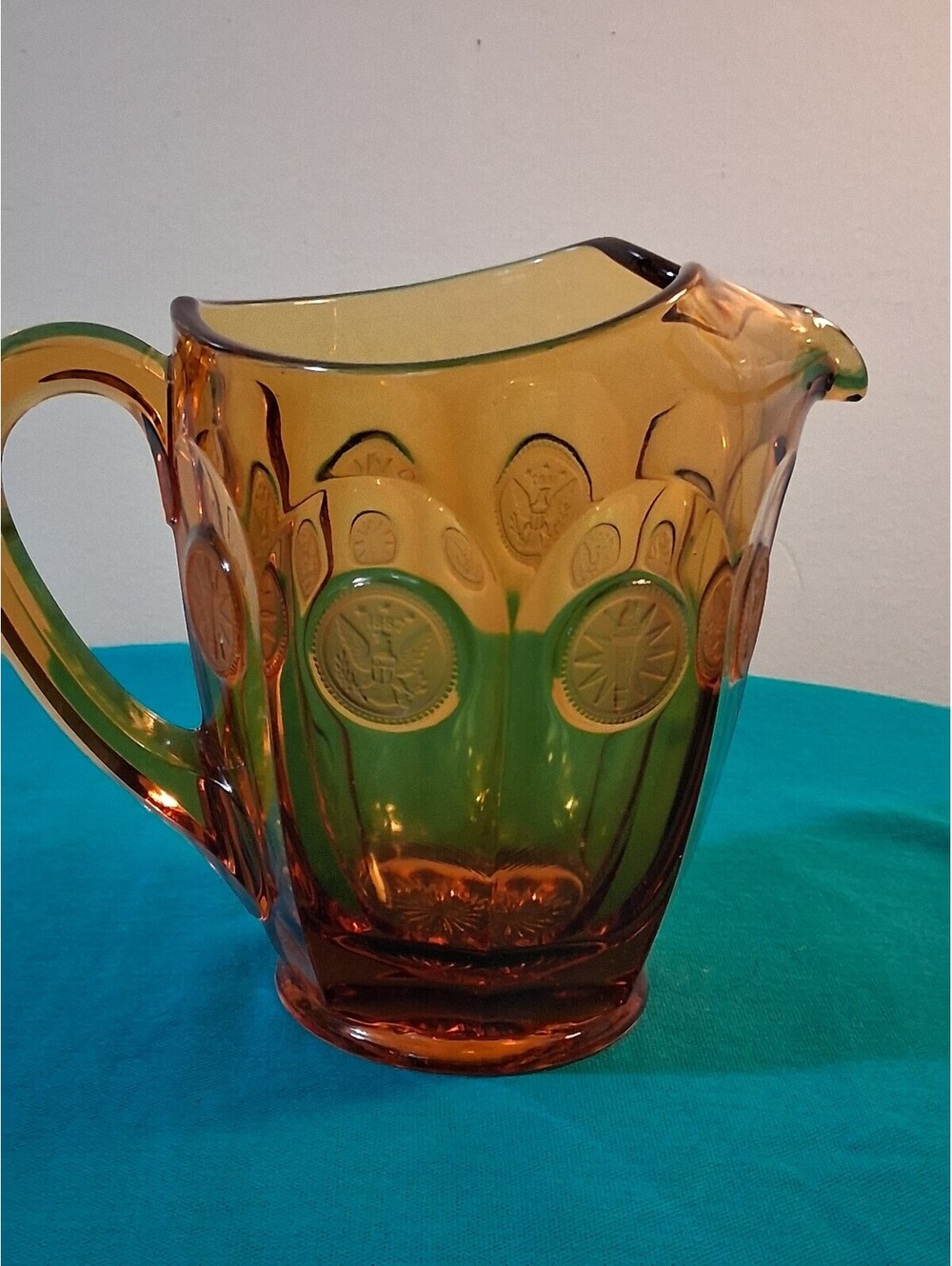 Vintage Amber Glass Pitcher with Embossed Medallion Design